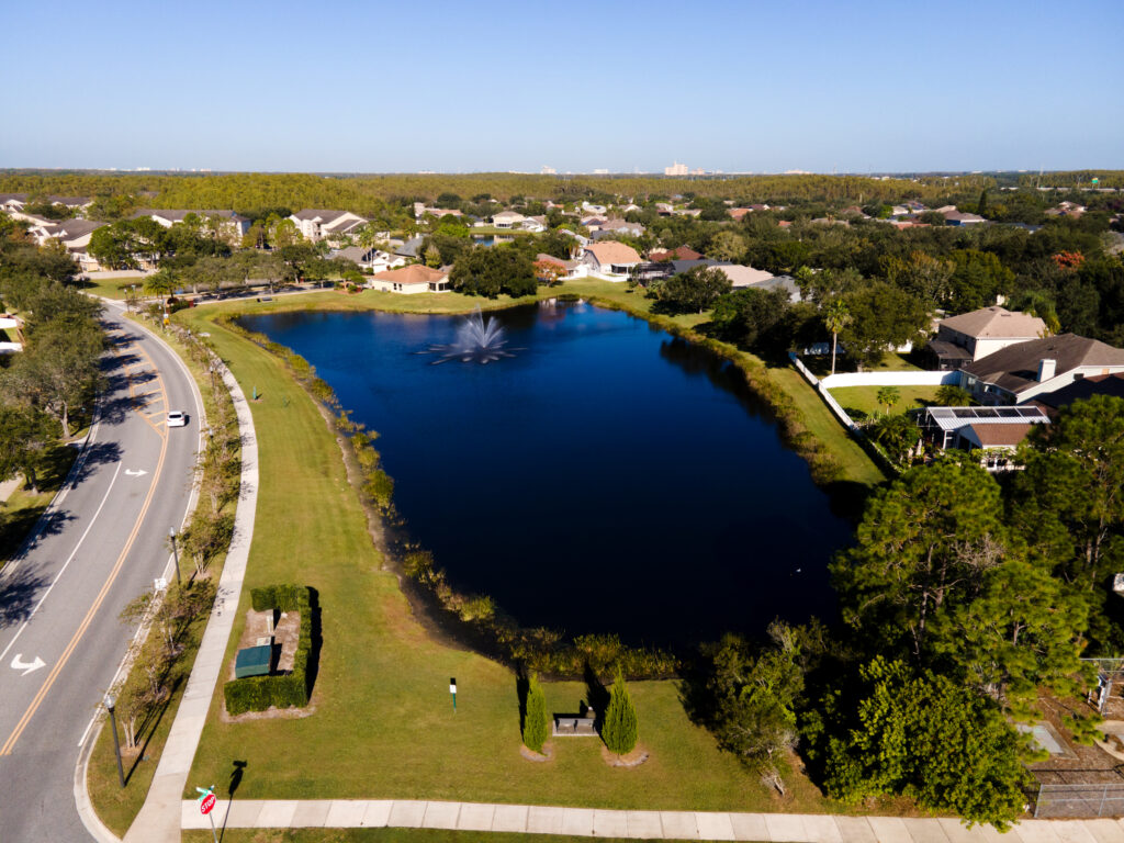Aerial view of a Falcon Trace lake with a fountain beside the main road